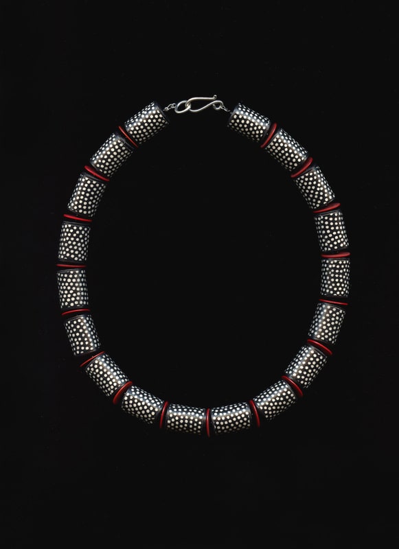 Halskette, schwarz, weiß gepunktet, mit roten Pailletten